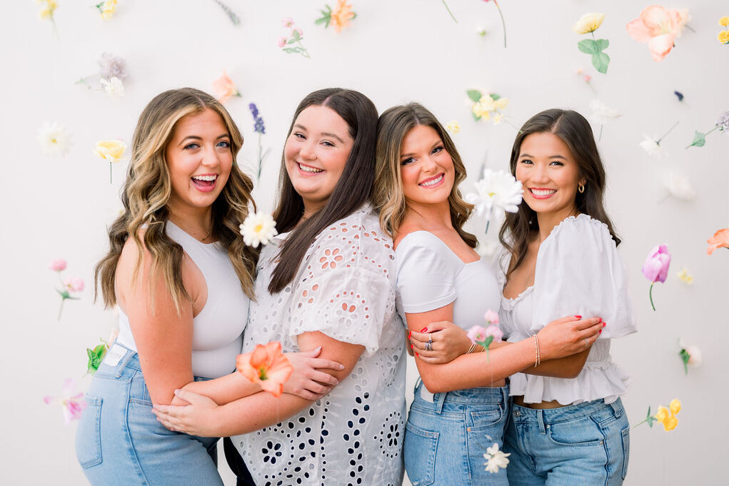 Four female models in a wall of flowing flowers