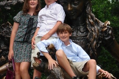 Three children sitting on statue