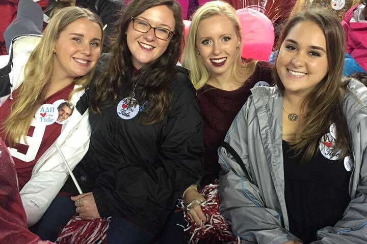 Four girls in stands at football game